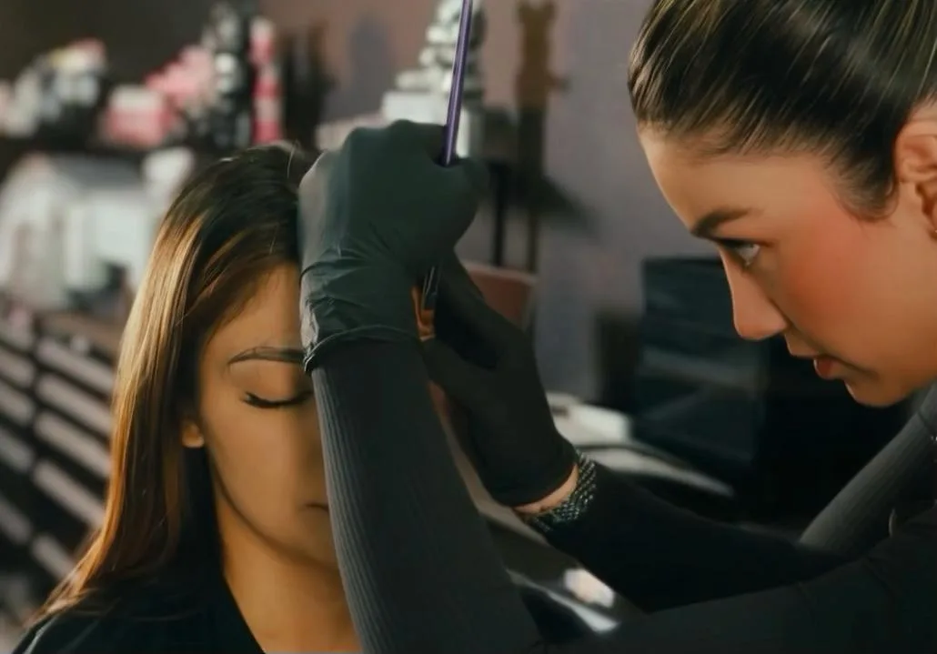 Permanent makeup instructor guiding a student during eyebrow practice